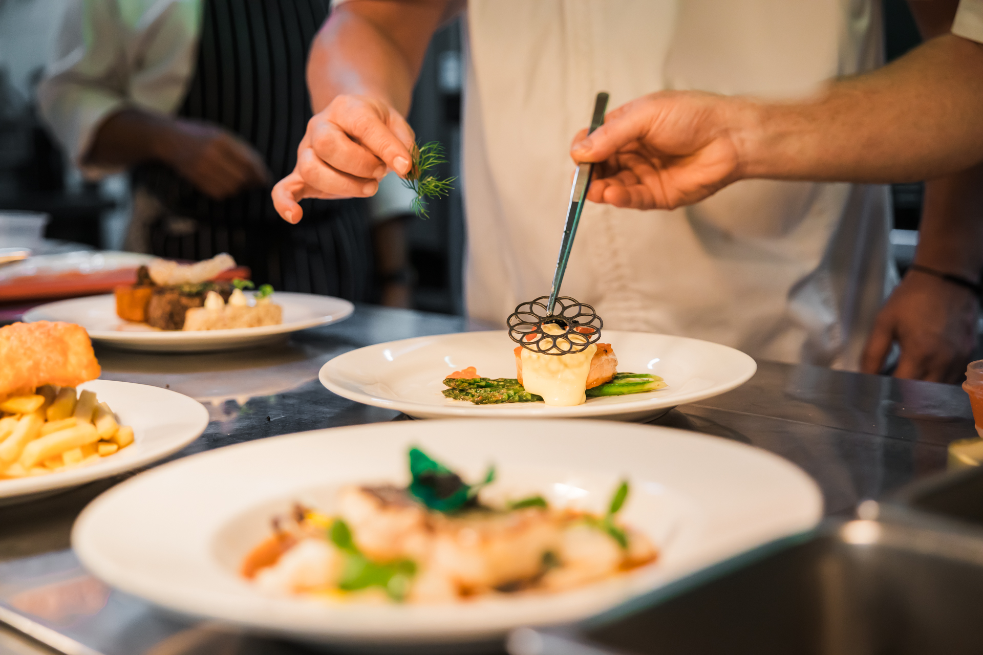 Chefs serving meals during dinner service.